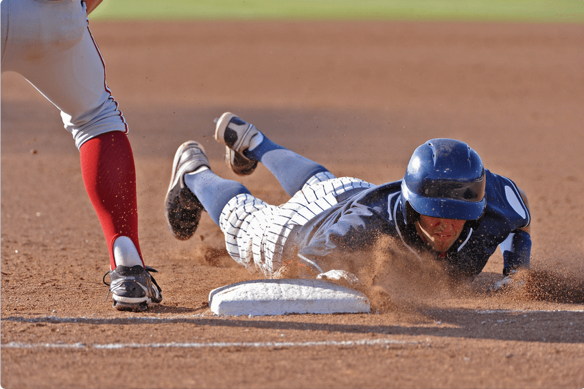 Baseball player sliding across the plate