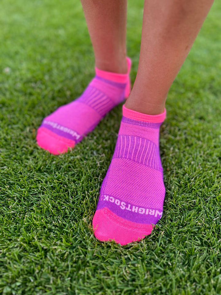 A person standing on grass in Wrightsock CoolMesh 2 Tab socks.